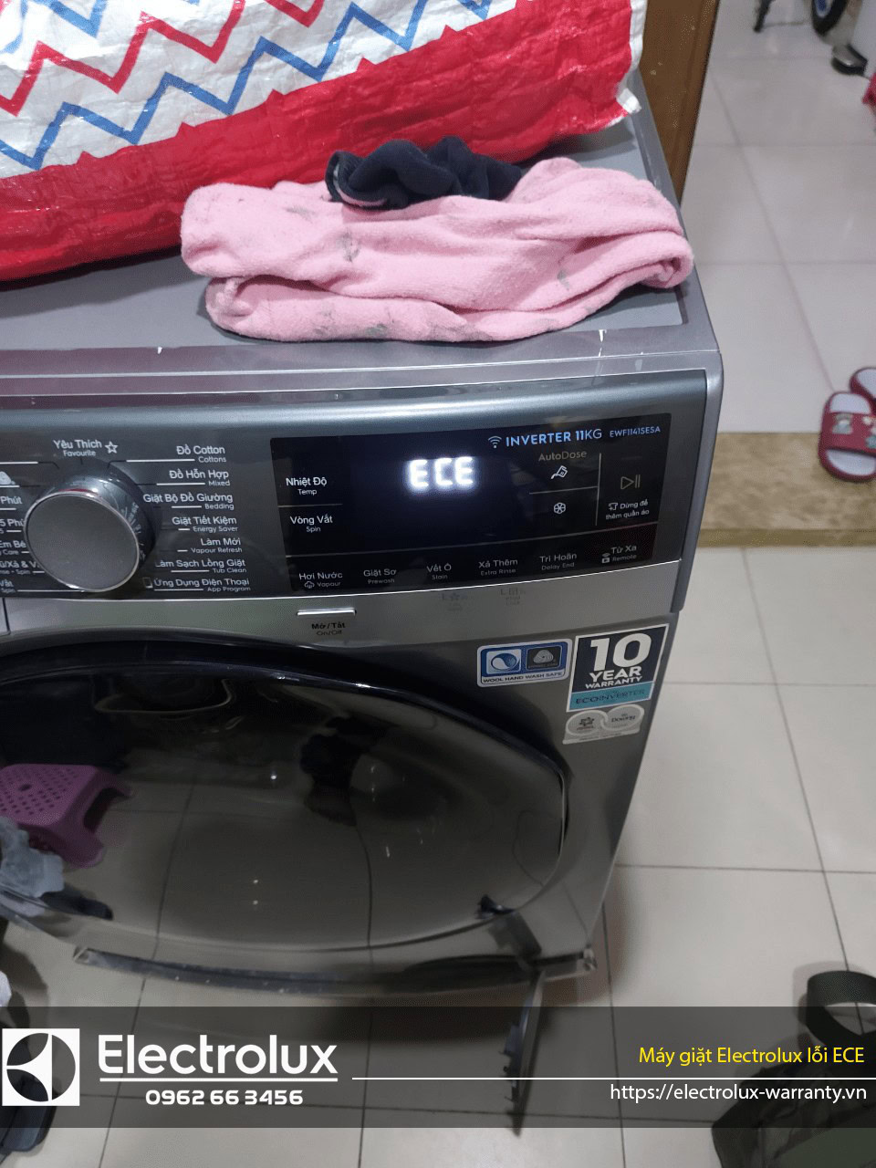 Washer with pink towel and clothes on top of it, close up shot of Electrolux washing machine, modern laundry appliance, appliance warranty, reliable washing machine service, home appliance care, Electrolux warranty service platform.